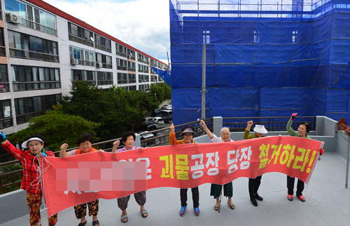 대구 동구 용계동 백자맨션 주민들이 29일 오후 서도산업(주) 신축공사 현장 앞에서 조망권과 공사소음 피해 등으로 고통을 호소하며 철거를 요구하고 있다. 정운철 기자 woon@msnet.co.kr
