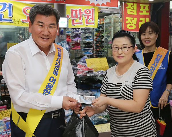 박인규(왼쪽) DGB대구은행장은 지난 5일 30여 명의 봉사단원과 함께 대구 서구 원고개시장을 찾아 명절나기에 필요한 건어물, 과일 등을 구매하고 상인들과 담소를 나눴다. DGB대구은행 제공