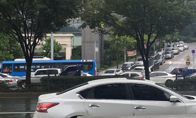 출근시간대에 대구 두산위브더제니스 단지에서 나오는 차량들이 달구벌대로에 진입하기 위해 줄을 길게 늘어 서 있다.