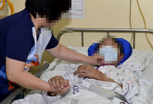 지난 5월 두개골 골절과 뇌출혈로 병상에 눕게 된 한병주(가명) 씨의 아버지와 병간호를 하는 한 씨 어머니. 성일권 기자 sungig@msnet.co.kr