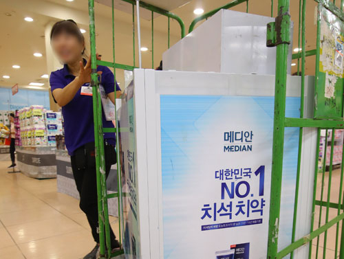 27일 한 마트 직원이 가습기 살균제에 사용된 화학물질 메칠클로로이소치아졸리논과 메칠이소치아졸리논 혼합물(CMIT/MIT)이 검출된 치약 브랜드의 홍보대를 매장에서 철수시키고 있다. 식품의약품안전처는 이 브랜드의 치약 11종을 회수한다고 26일 발표했다. 연합뉴스