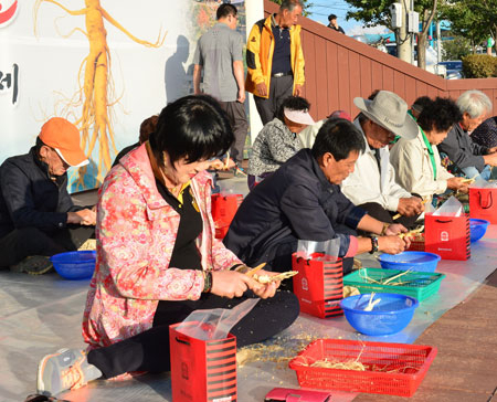 축제장을 방문한 관광객들이 인삼깎기 경연대회를 벌이고 있다.