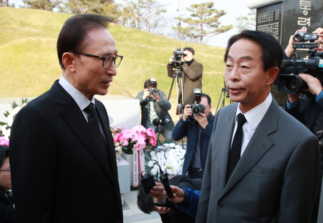 이명박(왼쪽) 전 대통령이 김영삼 전 대통령 서거 1주기를 하루 앞둔 21일 오후 서울 동작구 국립서울현충원에서 김 전 대통령 묘소를 참배한 뒤 김 전 대통령의 차남 현철 씨와 대화하고 있다. 연합뉴스