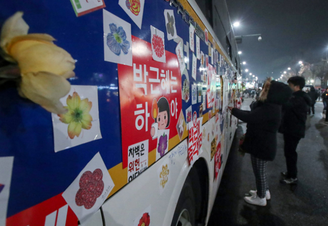 박근혜 대통령 촉구 제5차 촛불집회가 열린 26일 오후 서울 종로구 경복궁역 인근에 설치된 경찰차벽에 시민들이 준비한 꽃과 스티커가 붙어 있다.연합뉴스