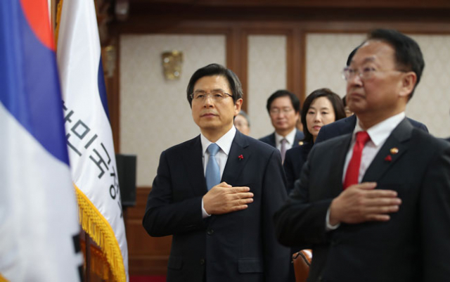 황교안 대통령 권한대행이 9일 오후 7시 서울 세종로 정부서울청사 19층 국무회의실에서 임시 국무회의를 주재, 국기에 대한 경례를 하고 있다. 이날 임시 국무회의는 탄핵소추의결서 송달 직후에 열린 것으로 대통령 권한대행으로서 첫 번째 일정이다. 연합뉴스