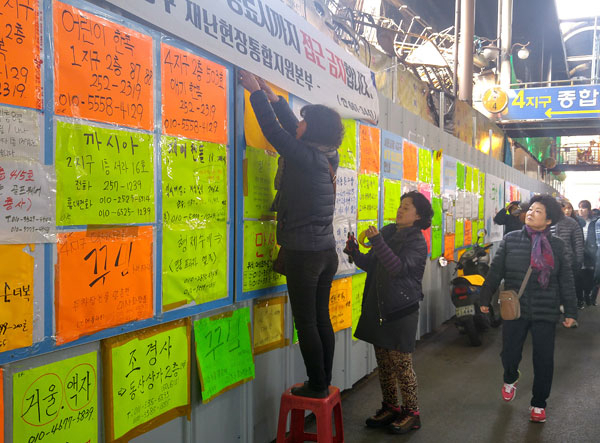 화마는 시장을 휩쓸고 지나갔지만 상인들마저 쓰러뜨리지는 못했다. 하늘을 보고 원망하고 땅을 치며 탄식을 하는 것도 잠시, 상인들은 다시 일어섰다. 대체상가를 알아보고 연말 대목 장사를 포기할 수 없다며 툴툴 털고 장사에 나섰다. 사진은 12일 오후 서문시장 4지구 화재현장을 둘러싼 접근 금지 펜스에 빼곡하게 붙어 있는 상인들의 이전 점포에서 영업을 한다는 스티커 사이로 새로운 스티커를 붙이고 있는 상인들. 이동관 기자 dkdk@msnet.co.kr