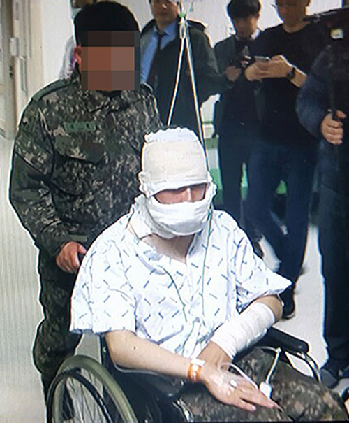 13일 울산의 한 군부대에서 발생한 폭발사고로 얼굴에 화상을 입은 병사가 치료를 받은 뒤 다른 병원으로 이송되고 있다. 연합뉴스
