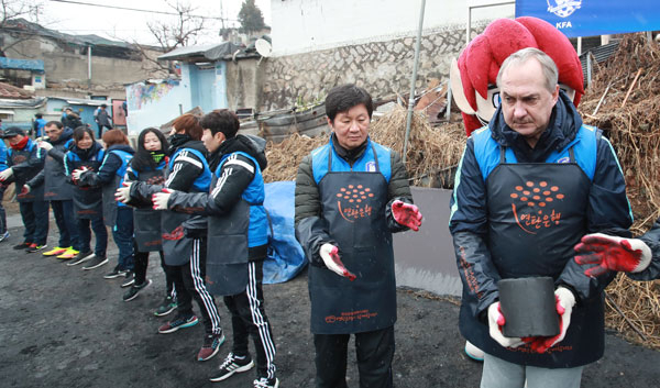 울리 슈틸리케 축구 대표팀 감독(오른쪽)과 정몽규 대한축구협회장 등 축구협회 관계자들이 14일 서울 중계본동 104마을에서 연탄 나르기 봉사를 펼치고 있다. 연합뉴스