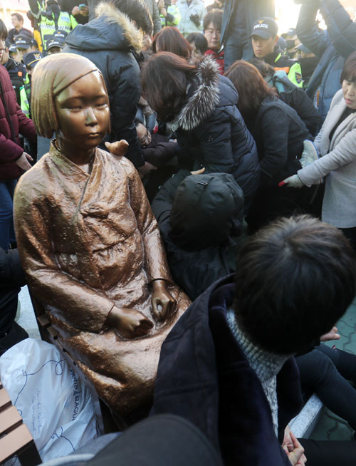 부산 시민단체가 28일 부산 일본영사관 앞에 기습적으로 소녀상을 설치하려다 무산되자 이를 항의하여 연좌농성을 벌이던 시민들을 구청직원들이 강제로 끌어내고 있다. 연합뉴스