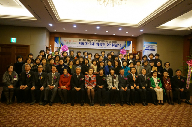 경산여성기업인협의회 서미자(왼쪽) 전 회장이 이영순 신임 회장에게 회기를 전달하고 있다.