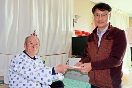 임정식(왼쪽) 씨가 성금 50만원이 든 봉투를 전달하고 있다. 경북공동모금회 제공