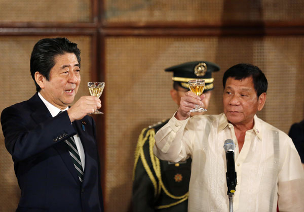 필리핀을 방문한 아베 신조(왼쪽) 일본 총리가 12일(현지시간) 마닐라의 말라카낭 대통령궁에서 로드리고 두테르테 필리핀 대통령과 국빈만찬을 하며 건배하고 있다. APㆍ연합뉴스