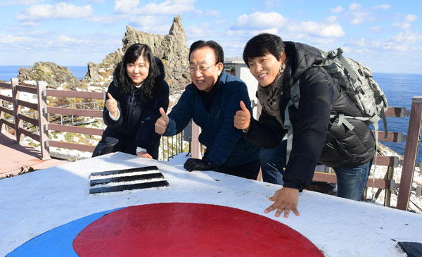 김관용(가운데) 경상북도지사가 25일 오전 국민대표 이기도(오른쪽) 씨, 강희경씨 와 독도를 방문해 독도 경계태세를 직접 둘러본 뒤 대한민국 영토 1번지 독도를 상징하는 엄지손가락을 세워 국토 수호 의지를 알리고 있다. 경북도 제공