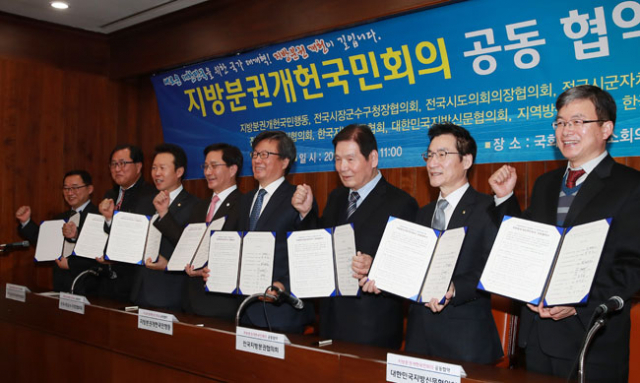 8일 서울 여의도 국회도서관에서 열린 지방분권개헌국민회의 공동 협약 및 출범식에서 참석자들이 협약서를 들어 보이고 있다. 한국지방신문협회 매일신문 최정암 서울지사장(오른쪽부터), 대한민국지방신문협의회 김중석 강원도민일보 사장, 전국지방분권협의회 정해걸 경상북도지방분권협의회 의장, 지방분권개헌국민행동 김형기 경북대 교수, 전국시장군수구청장협의회 최명희 강릉시장, 전국시군자치구의회의장협의회 황영호 청주시의회 의장, 한국지역언론인클럽 김진수 회장, 지역방송협의회 유병호 공동의장. 연합뉴스