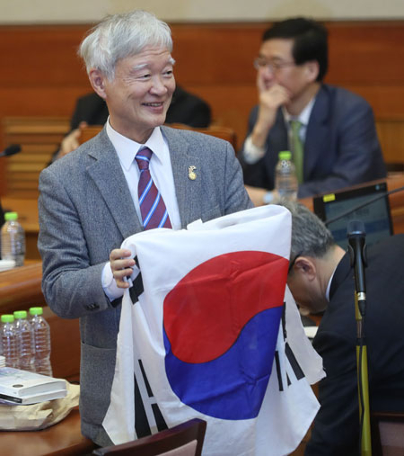 14일 오전 서울 종로구 헌법재판소에서 열린 박근혜 대통령 탄핵심판 13차 변론.대통령 측 대리인단 서석구 변호사가 방청석을 향해 태극기를 펼쳐 보이고 있다. 연합뉴스