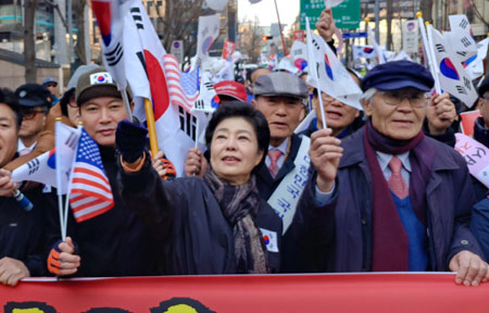 3월 첫 주말인 4일 오후 서울 종로구 을지로1가에서 박근혜 대통령 동생 박근령(왼쪽 둘째) 씨와 남편 신동욱(왼쪽) 씨가 대통령 탄핵 기각 촉구 집회 참가자들과 함께 행진을 하고 있다. 오른쪽은 보수 논객 조갑제 조갑제닷컴 대표. 연합뉴스