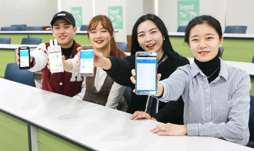학생들이 스마트 출결시스템이 적용된 스마트폰을 보여주고 있다.
