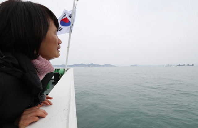 23일 오전 전남 진도군 세월호 인양 구역에서 미수습자 가족이 세월호 인양 과정을 보면서 오열하고 있다. 연합뉴스