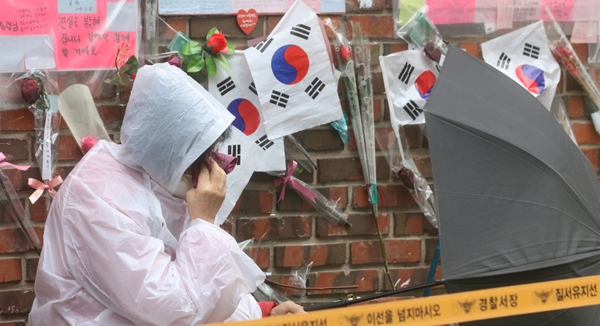 박근혜 전 대통령이 구속된 31일 오전 삼성동 박 전 대통령 자택 앞에 한 지지자가 눈물을 닦고 있다. 연합뉴스