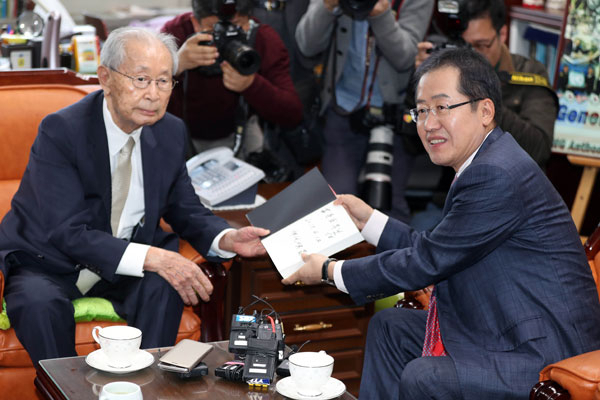 홍준표 자유한국당 대선 후보가 12일 오후 서울 용산구 전쟁기념관에서 백선엽 장군을 예방하고 국가안보에 대한 조언을 구한 뒤 책을 선물받고 있다. 연합뉴스