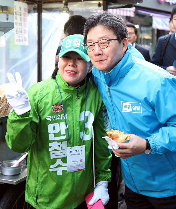 유승민 바른정당 후보가 19일 서울 노원역 앞에서 출근길 시민들을 상대로 한 유세를 마친 뒤 안철수 국민의당 후보 선거운동원과 기념촬영을 하고 있다. 연합뉴스