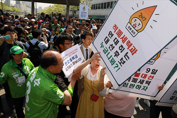 1일 오전 서울 청계천 버들다리 전태일 동상 앞에서 국민의당 안철수 대선후보의 지지자와 대학교 반값 등록금 공약을 촉구 피켓을 든 대학생들이 몸싸움을 하고 있다. 안 후보는 이 반대시위로 전태일 동상 헌화를 하지 못하고 발길을 돌렸다. 연합뉴스