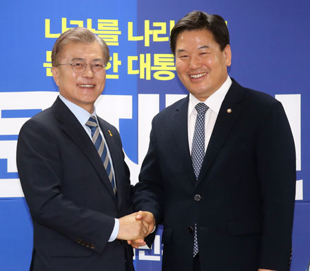 더불어민주당 문재인 대선 후보가 4일 서울 여의도 당사에서 열린 무소속 홍의락 의원 복당식에서 홍 의원과 악수하며 얘기를 나누고 있다.연합뉴스
