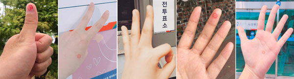 제19대 대통령선거 사전투표 첫날인 4일 투표를 마친 유권자들이 다양한 손가락 모양으로 인증샷을 찍고 있다. 연합뉴스
