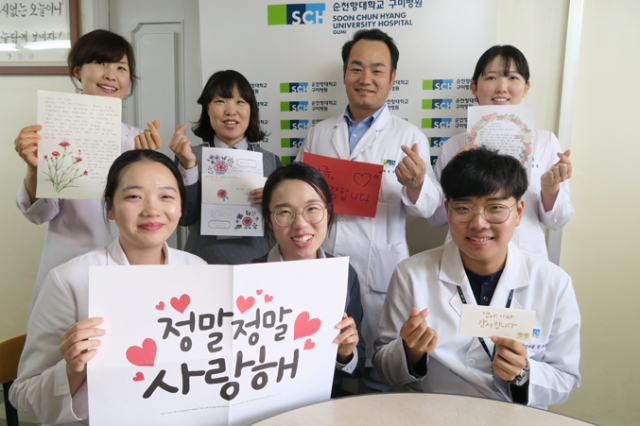 순천향대 구미병원 직원들이 가족에게 전할 편지를 쓴 후 기념사진을 찍고 있다.