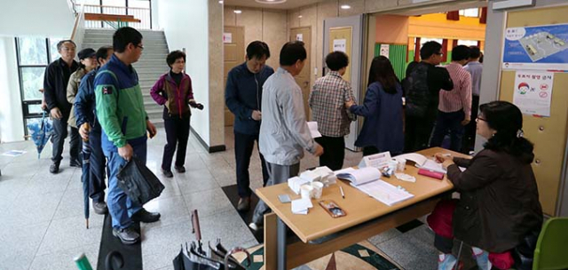 제19대 대통령 선거일인 9일 대전 서구 주민들이 투표를 려고 한 초등학교에 마련된 투표소에 길게 줄을 서 있다. 연합뉴스