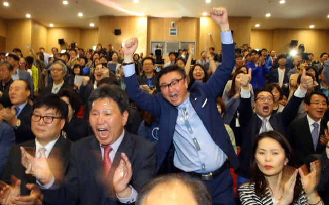 더불어민주당 당직자들이 9일 오후 서울 여의도 국회의원회관 대회의실에서 투표 종료와 함께 발표된 TV 방송사의 투표자 출구 조사결과를 보며 환호하고 있다. 연합뉴스