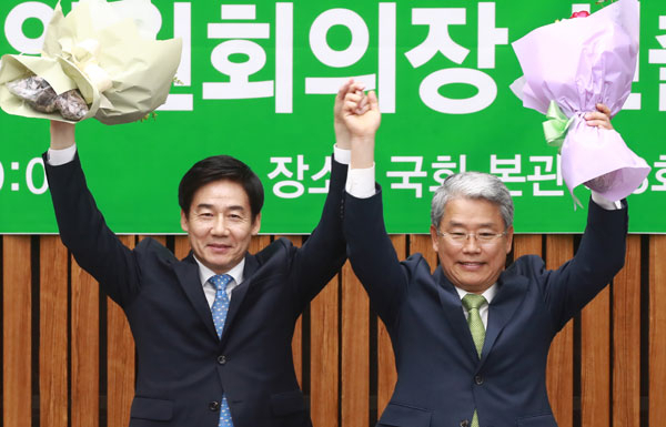 김동철(오른쪽) 국민의당 신임 원내대표와 이용호 정책위의장이 16일 오전 국회 본청에서 열린 의원총회에서 새 원내지도부로 선출된 뒤 꽃다발을 들어 보이고 있다. 연합뉴스