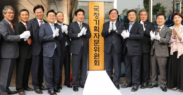 국정기획자문위원회 현판식이 22일 오후 서울 종로구 통의동 금융감독원연수원에서 열렸다. 김진표(현판 왼쪽) 위원장, 홍남기 국무조정실장, 김태년 더불어민주당 정책위의장 등 참석자들이 박수를 치고 있다. 연합뉴스