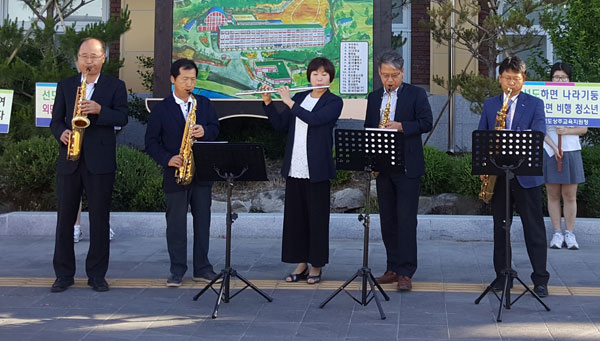 지난 26일 오전 7시 30분쯤 상주 우석여고 정문 맞은편에서 이 학교 교사들이 등굣길 학생들을 위해 플루트와 색소폰 연주를 하고 있다. 우석여고 제공