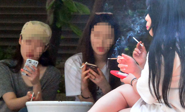 제30회 세계 금연의 날(5월 31일)을 하루 앞둔 30일 오후 대구 중구 남산동의 한 빌딩 쉼터에서 흡연할 곳을 찾지 못한 애연가들이 옹기종기 모여 담배를 피우고 있다. 흡연자들이 단속을 피해 금연구역 밖 특정 장소로 몰리면서 비흡연자들이 어깨너머로 담배연기를 마시는 등 고통을 호소하고 있다. 정운철 기자 woon@msnet.co.kr