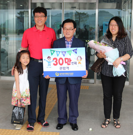 백선기 칠곡군수가 30만 번째 칠곡호국평화기념관 입장객 조창열 씨 가족에게 꽃다발과 축하 인사를 전하고 있다. 칠곡군 제공