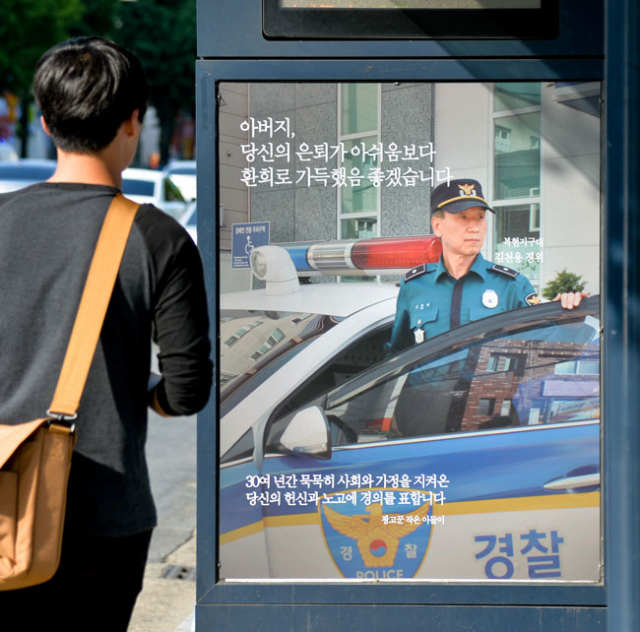 11일 대구 복현우체국 앞 버스정류장에 정년퇴직을 앞둔 경찰관 아버지 김천용 경위를 위해 광고 관련 회사에 다니는 작은 아들 성진 씨가 제작한 광고가 걸려 눈길을 끈다. 광고에는 근무 복장을 한 아버지 사진을 배경으로 