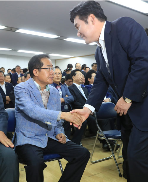 15일 오전 서울 여의도 자유한국당 서울시당에서 열린 당사 이전 개소식에서 홍준표(왼쪽) 전 경상남도지사와 원유철 의원이 악수를 하고 있다. 연합뉴스