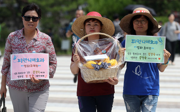 26일 서울 청와대 입구 분수대 앞에서 사드한국배치저지전국행동 관계자들과 성주에서 참외 농사를 짓는 김정숙 씨(가운데)가 영부인 김정숙 여사에게 보내는 사드 배치 반대의 뜻을 담은 편지를 낭독하는 행사를 하고 편지와 참외를 전달하기 위해 청와대로 향하고 있다. 연합뉴스