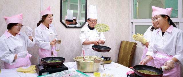 어름사니 단원들이 실버타운 어르신들에게 대접할 부침개를 직접 만들면서 환하게 웃고 있다. 칠곡군 제공