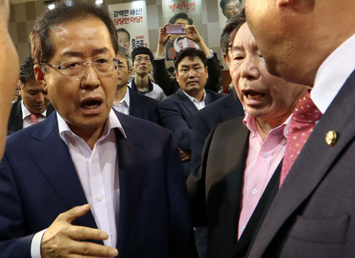 26일 대전 한밭체육관에서 열린 당 대표 선출을 위한 제2차 전당대회에 참석한 홍준표 후보가 지난 대선 전 바른정당 합류를 시도했다는 의혹을 제기한 원유철 후보의 발언에 화가 나 기념사진을 찍지 않고 행사장을 나가고 있다. 연합뉴스