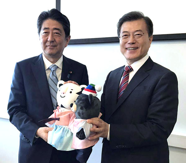 문재인 대통령이 7일 오전 러시아 블라디보스토크 극동연방대학에서 아베 신조 일본 총리와 정상회담을 마친 뒤 2018 평창동계올림픽 마스코트인 수호랑과 반다비를 선물하고 있다. 연합뉴스