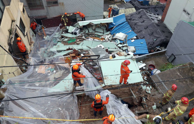 남부 해안지역에 호우경보가 내려진 11일 오전 부산 중구 동광동에서 집중호우로 1∼2층짜리 주택 3채가 잇따라 무너져 119구조대가 추가 붕괴를 막는 작업을 하고 있다. 2017.9.11/연합뉴스
