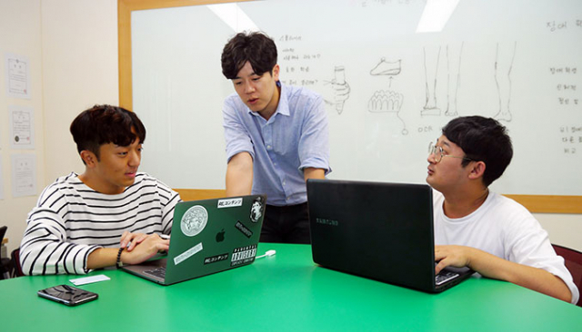 대구대 재활산업학과 작업실에서 임미덥(가운데) 씨와 창업동아리 학생들이 곧 출시를 앞둔 차량용 광고 앱에 대해 상의하고 있다. 대구대 제공