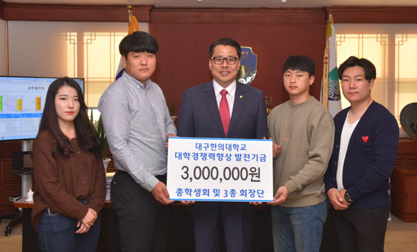 학생자치기구 대표가 발전기금을 전달하고 있다.
