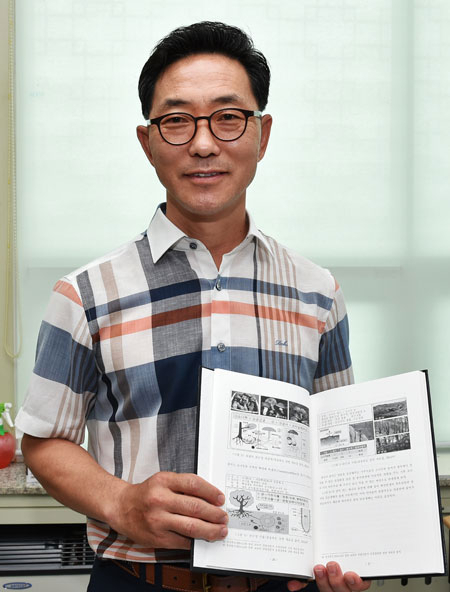 송이 박사 권오웅 영덕군 산림과장이 지난해 자신이 발표한 송이 관련 논문을 펼쳐보이고 있다. 권 과장은 논문을 바탕으로 영덕군의 송이버섯 생태환경 보고서 발간을 총괄했다. 김대호 기자