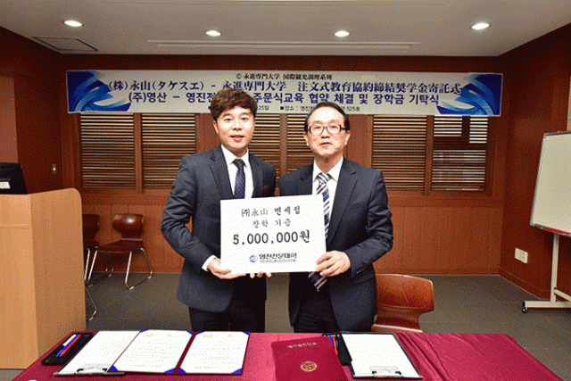 김종구(왼쪽) 에이산면세점 전무가 장학금을 전달하고 있다. 영진전문대 제공