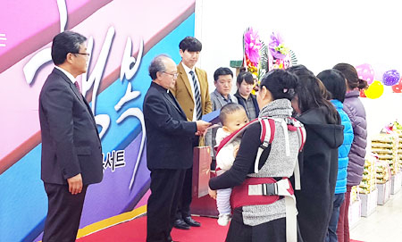 원유술 천주교대구대교구 제4대리구 교구장 대리 신부가 이주민들에게 고향 방문 증서를 전달하고 있다.