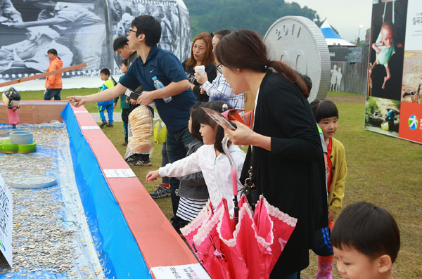 낙동강세계평화 문화 대축전장에 마련된 평화의 동전 밭에 축전 관람객들이 동전을 던져넣고 있다. 칠곡군 내 각급 학교와 사회단체 등에서 모은 동전은 에티오피아 돕기 종잣돈 역할을 톡톡히 하고 있다. 칠곡군 제공