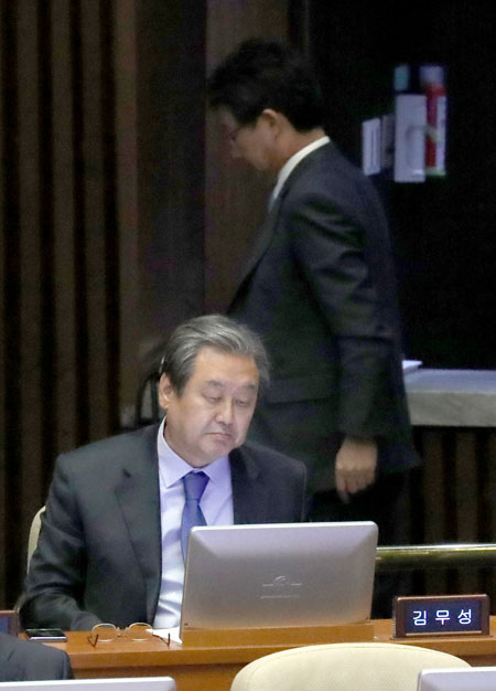 유승민 바른정당 국회의원이 9일 오후 국회 본회의장을 나서며 바른정당을 탈당해 자유한국당에 복당한 김무성 국회의원 뒤로 지나가고 있다. 연합뉴스
